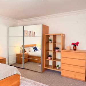 a bedroom with a bed and a glass closet at Modern 3-Bedroom Retreat Just Steps from Wembley Stadium in London +18 photos