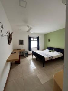 una camera da letto con un letto e una scrivania di 27 Cafe Zanzibar Airport Hotel a Zanzibar City
