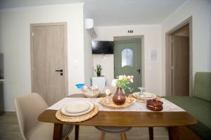 a dining room table with plates and flowers on it at Agnanti Studios in Roussopoúlion