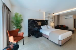 a hotel room with a bed and a chair at Philia Center Suites in Rhodes Town +196 photos