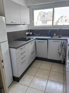 een keuken met witte apparatuur en een raam bij Apartment facing the large beach in Quiberon