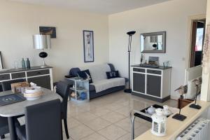 een woonkamer met een bank en een tafel bij Apartment facing the large beach in Quiberon