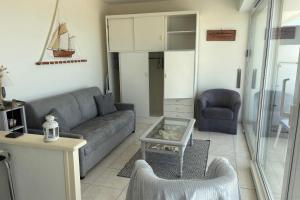 een woonkamer met een bank en een tafel bij Apartment facing the large beach in Quiberon +12 foto's