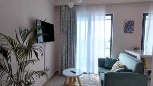 un salon avec un canapé bleu et une plante dans l'établissement Uzuri studio apartment, à Nairobi