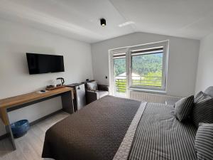 a bedroom with a bed and a tv and a window at Chicago Hotel in Yaremche
