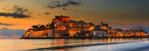 a castle on a hill in the water at sunset at Hostal Susi in Peñíscola
