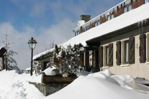 ein schneebedecktes Haus neben einem Gebäude in der Unterkunft Hotel La Grange in Boutx