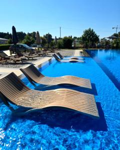a swimming pool with chairs and blue water at Lula Apartments 2 in Ulcinj