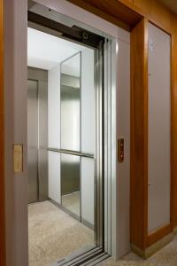 una porta scorrevole in vetro con specchio in una stanza di 3E Apartamento encantador a 3 minutos da praia a Matosinhos