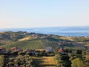 a village on a hill with the ocean in the background at Appartamento spazioso montone vista mare in Montone