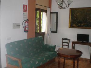 - un salon avec un canapé vert et une table dans l'établissement Apartamentos Rurales El Cañuelo de Carcabuey, à Carcabuey