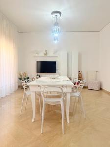 una sala da pranzo bianca con tavolo e sedie bianchi di Home Sisters a Trapani