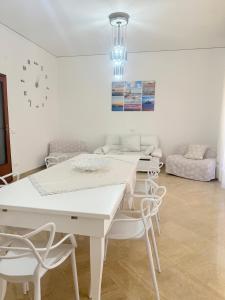 una sala da pranzo bianca con tavolo e sedie bianchi di Home Sisters a Trapani