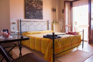 a bedroom with a bed with a yellow blanket and a table at White Beach in Alghero