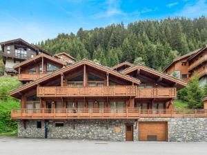 ein großes Holzhaus mit einem großen Balkon in der Unterkunft Bel appartement moderne, proche des pistes, à Méribel - FR-1-565-98 in Les Allues