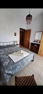 1 dormitorio con 1 cama con mesa y lámpara de araña en The house by the sea, en Skála Foúrkas