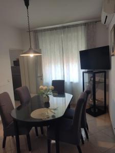 een eetkamer met een tafel, stoelen en een televisie bij Apartments Mimi Omis in Omiš