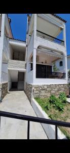 Un gran edificio blanco con una escalera al frente. en The house by the sea, en Skála Foúrkas 8 fotos más