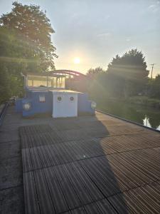 a wooden deck with the sun setting in the background at Péniche LOFT la campanella in Maizy