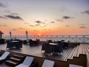 een terras met tafels en stoelen en een zonsondergang bij VEZO BEACH HOTEL Morondava in Morondava