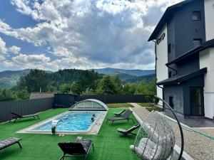 a backyard with a swimming pool on a green lawn at Chicago Hotel in Yaremche