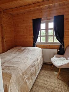 a bedroom with a large bed and a window at Cozy Family cabin by the lake in Ólafsfjörður