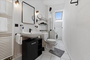a white bathroom with a sink and a toilet at Maisonette-Wohnung in der Alten Post in Mechernich +11 photos