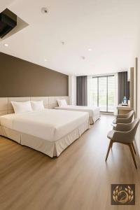 una grande camera da letto con due letti e una sedia di Kim Thanh Boutique Hotel Nha Trang a Nha Trang