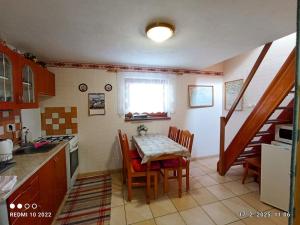 a kitchen with a table and chairs and a staircase at Apartmán " Matej" in Smrečany
