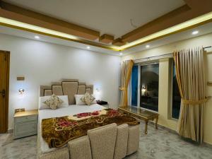a bedroom with a king sized bed and a couch at Mountains escape in Murree