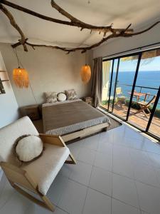 Un dormitorio con una cama y vista al mar. en Comfort Viewpoint Sesimbra - parking at center, en Sesimbra