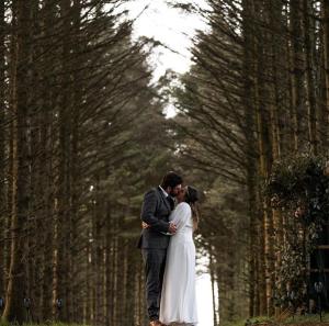 a bride and groom kissing in a forest at Yurt Pitch - TY GRUG RETREAT in Puncheston