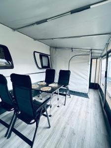 un grupo de sillas y una mesa en una tienda en Mietwohnwagen 49, en Hüde