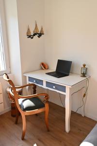un escritorio blanco con un ordenador portátil y una silla en L'Auberge Du Roch, en Saint-Pierre-Quiberon