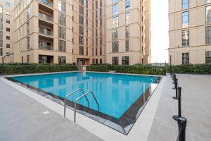 a large swimming pool in front of a building at 1BR Private Apartment - The Sultans Loft by Blue Cloud Holidays in Sharjah Intl