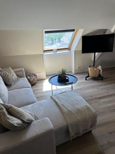 a living room with a couch and a table at Un nid en ville - Studio centrale, cosy et calme in Pacy-sur-Eure