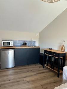 a kitchen with a counter and a table and a microwave at Un nid en ville - Studio centrale, cosy et calme in Pacy-sur-Eure +4 photos