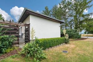 una casa blanca con una valla al lado de un patio en Bungalow 131, en Zadelsdorf