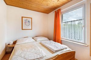 Un dormitorio con una cama y una ventana grande. en Bungalow 131, en Zadelsdorf