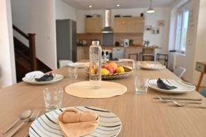 una mesa de comedor con un bol de fruta. en L'Auberge Du Roch, en Saint-Pierre-Quiberon