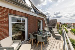 a balcony with a glass table and chairs at Fördeloge in Laboe