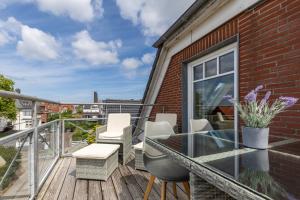 a balcony with a glass table and chairs at Fördeloge in Laboe +22 photos