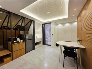 a kitchen with a table and a refrigerator at Blueduck hotel in Seoul