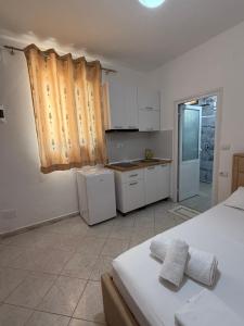 a kitchen with white cabinets and a white refrigerator at Guest House Kloen in Vlorë