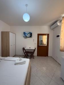 a room with two beds and a table in it at Guest House Kloen in Vlorë