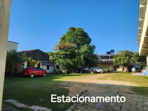 a house with cars parked in a yard at POUSO DO BEIJA FLOR in Paraty