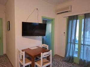 a dining room with a table and a flat screen tv at Vitamin sea Studio in Panayía