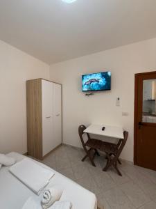 a room with two beds and a table and a desk at Guest House Kloen in Vlorë
