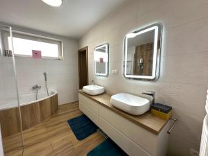 a bathroom with two sinks and a mirror at Family House Teplice in Trenčianske Teplice