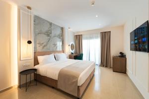 a bedroom with a large bed and a large window at Philia Center Suites in Rhodes Town